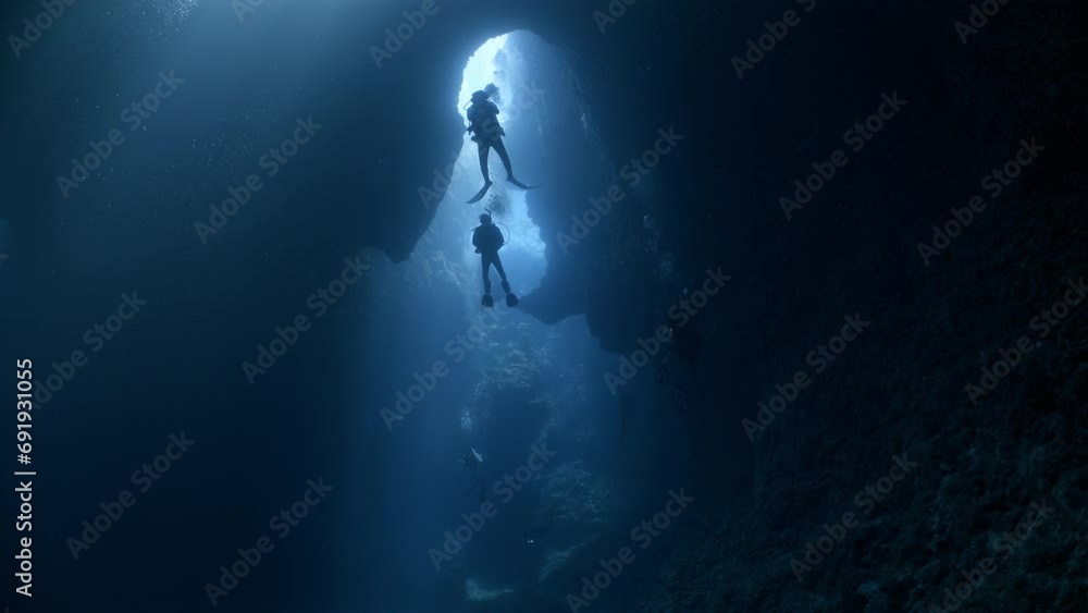 SCUBA Divers explore a large underwater cavern