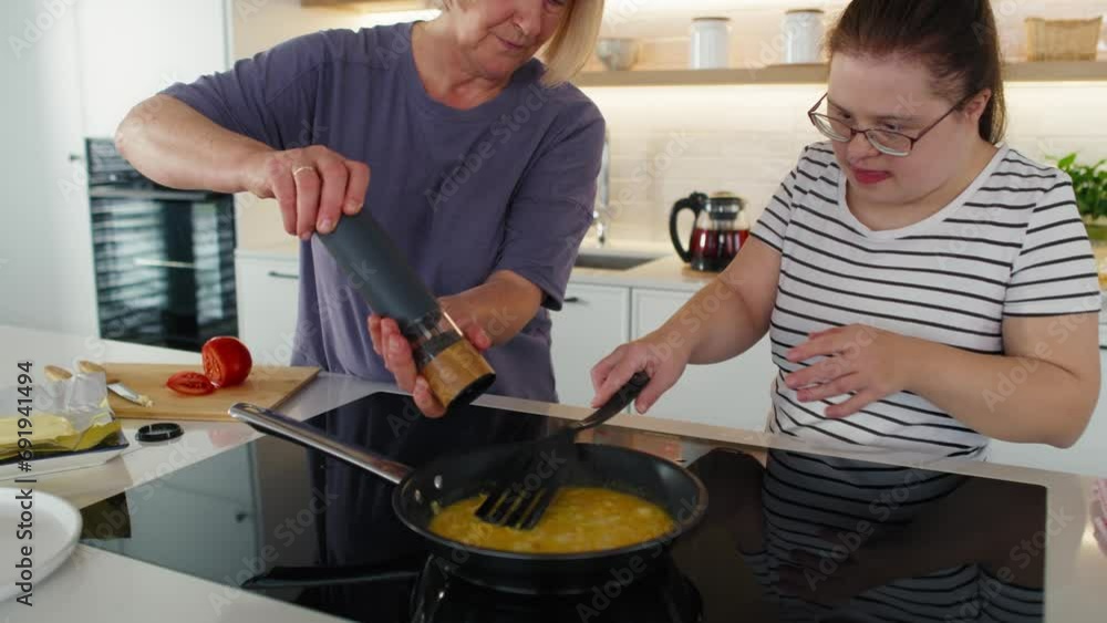 Down syndrome woman helping her mother in preparing breakfast. Shot with RED helium camera in 8K. Down syndrome woman helping her mother in preparing breakfast. Shot with RED helium camera in 8K.