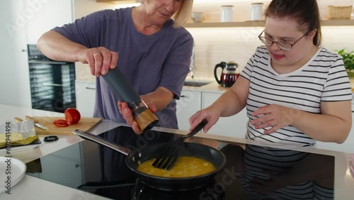 Down syndrome woman helping her mother in preparing breakfast. Shot with RED helium camera in 8K.    