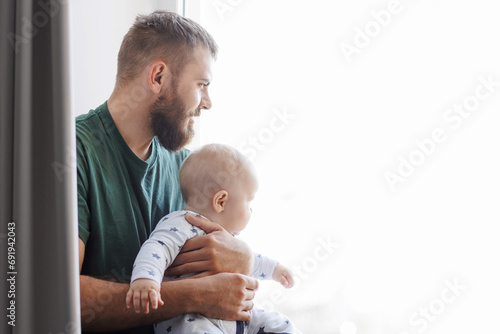 Father hugs baby boy son in living room. Concept lifestyle parenting fatherhood moment photo