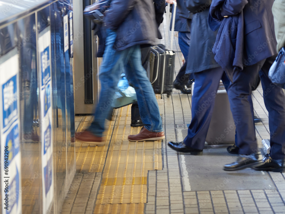 Fototapeta premium 冬の新幹線のホームの電車待ちの人々の姿