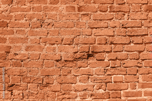 Wall of old red brick  background  peach fuzz tinting.