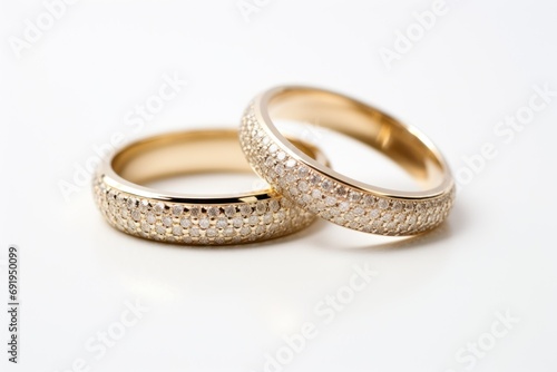  a couple of wedding rings sitting next to each other on top of a white surface in front of a white background.