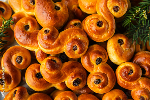 Big plate with pile of homemade Swedish saffron buns lussekatter on linen tablecloth .