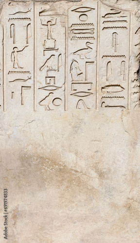 Vertical background with ancient Egyptian hieroglyphs on stone wall, Egypt, Africa. Backdrop with sandstone carving with hieroglyph. Mock up template. Copy space for text