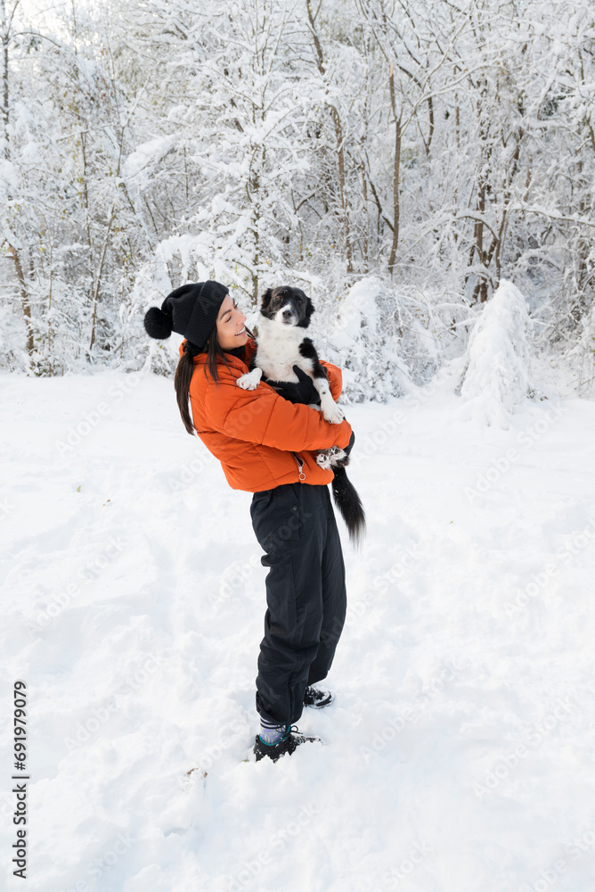 Woman Hugging  Her Cute Stray Dog in the Winter Forest . Pet and Owner Outdoor