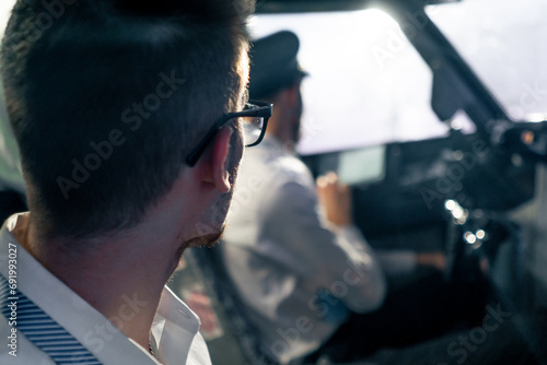 young pilots in the cockpit of the plane control air transport during a long distance flight simulator