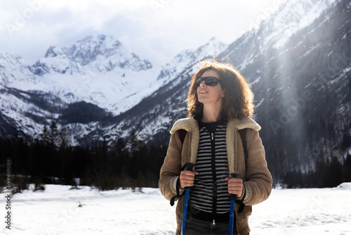 Confident Adult Woman Hiker Serene Expression While Enjoying a Recreational Hike in Winter Snowy Mountains Landscape