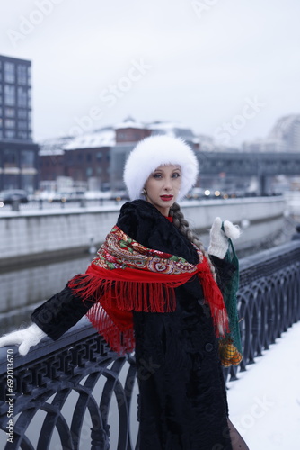 Woman with big braid in brown retro fur coat in winter street with snow. Winter cold weather. Girl with string bag and jumbles, in white fur gloves and in high red boots. Smile. Vintage, soviet time.