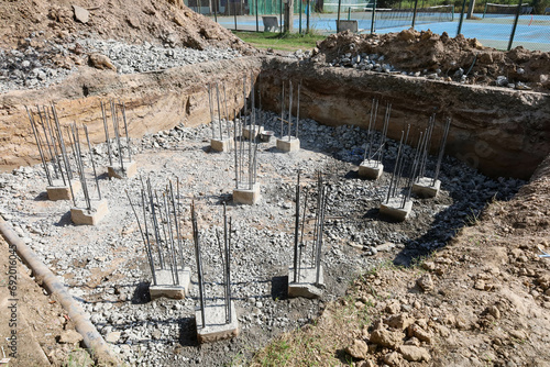Pile foundation pit. Concrete pier with rebar in outdoor pit for foundation at large tower construction site with selective focus. photo