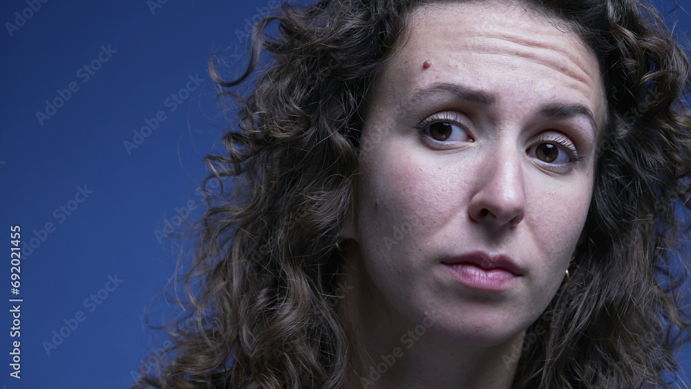 Woman in doubt listening close-up face with question mark expression lifting eye brow feeling confused