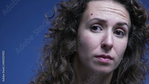 Woman in doubt listening close-up face with question mark expression lifting eye brow feeling confused