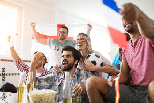Canvas Print Cheerful and happy group of friends watching olympic games on tv.