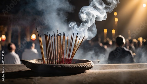 Indian incense sticks burn and form clouds of wavy fumes smoke. Crowd of people gathered on street at night. Republic Day, India. photo