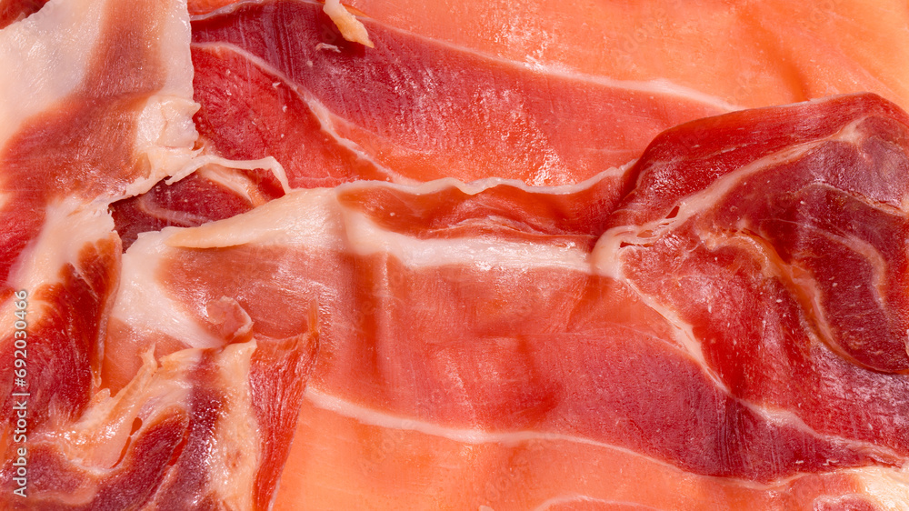 Thinly sliced jamon isolated on white background. Thinly sliced jamon isolated on white background.