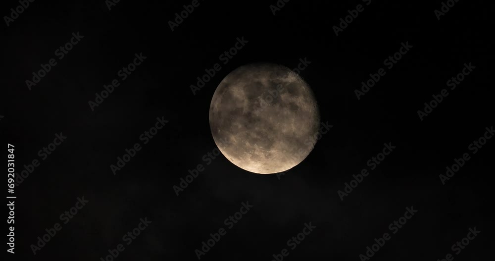 full moon in the night with some clouds passing.