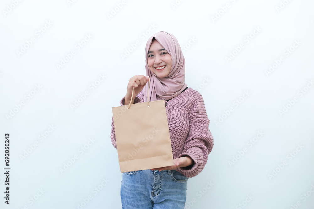 A happy beautiful young Asian woman is carrying shopping bag on white background A happy beautiful young Asian woman is carrying shopping bag on white background
