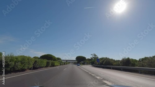 First person view, FPV, from dashcam of car driving in the beautiful Spanish countryside towards Seville, Andalusia, Spain, Europe. Road trip video in POV, with bright, sunny, blue sky photo