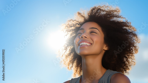 A African woman breathes calmly looking up isolated on clear blue sky photo