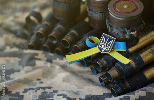 Ukrainian symbol on machine gun belt lies on ukrainian pixeled military camouflage close up photo