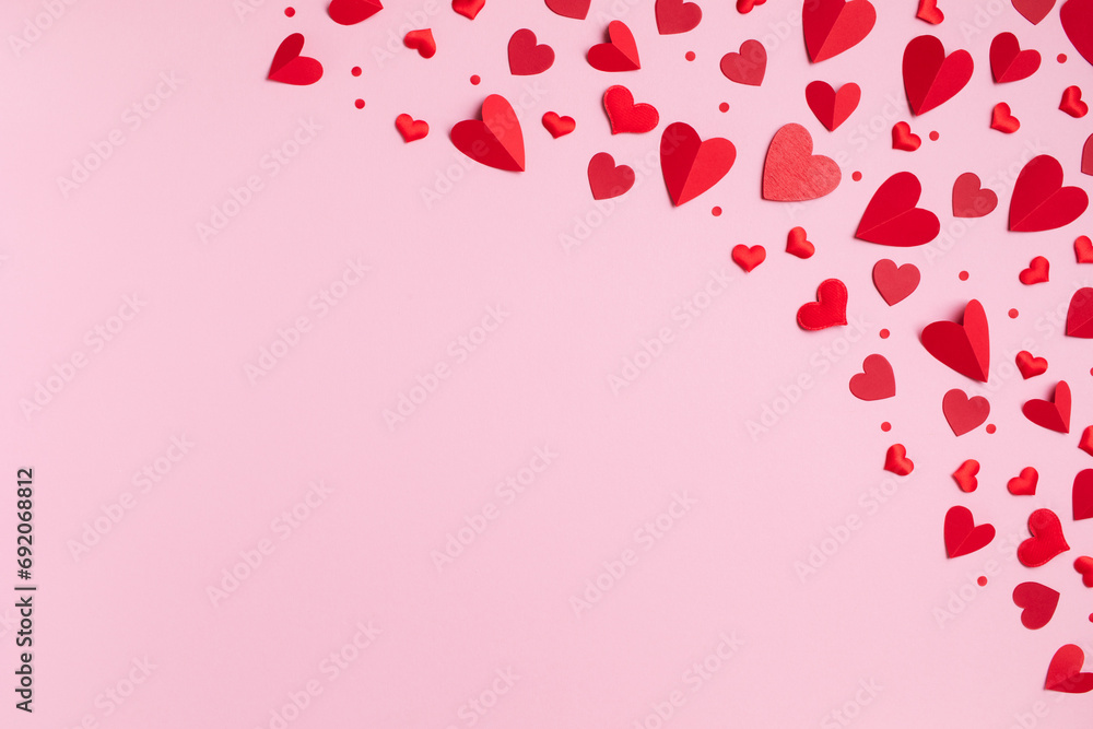 Valentine day greeting card with border of red hearts on pastel pink background top view. Flat lay festive composition.