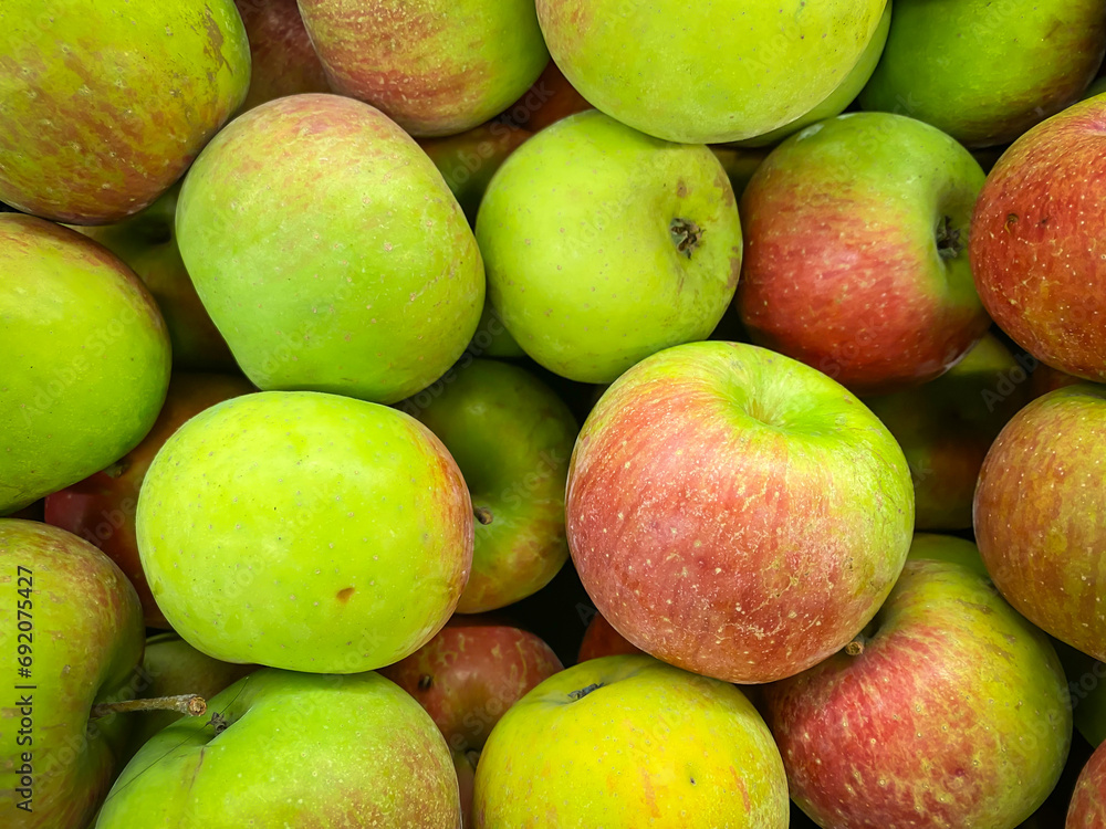 Pile of fresh reddish green apples in the supermarket. Abstract food fruit and vegetables texture for wallpaper or website backgrounds. Pile of fresh reddish green apples in the supermarket. Abstract food fruit and vegetables texture for wallpaper or website backgrounds.