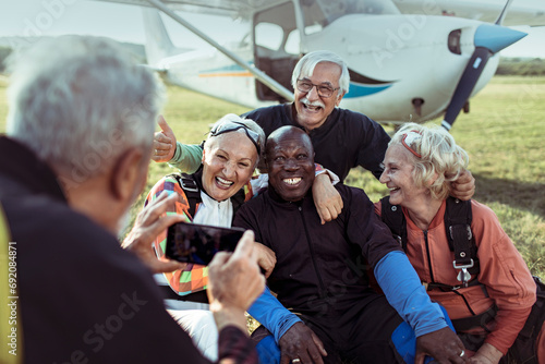 Group of senior friends celebrating their skydiving adventure together photo