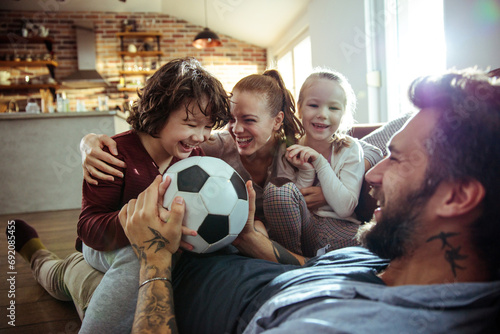 Parents and Children Laughing and Playing with a Soccer Ball Indoors