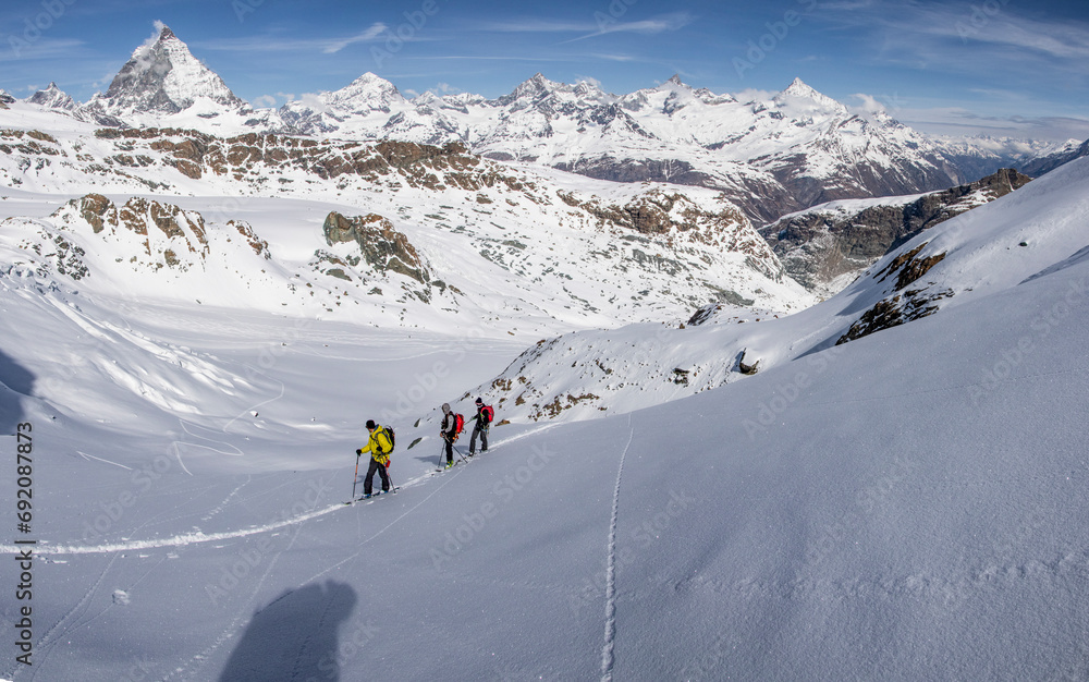 Side view of unrecognizable tourists skiing on snow-capped mountain slope in Zermatt Side view of unrecognizable tourists skiing on snow-capped mountain slope in Zermatt