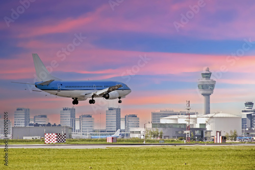 Airplane landing at Schiphol airport in the Netherlands at sunset photo