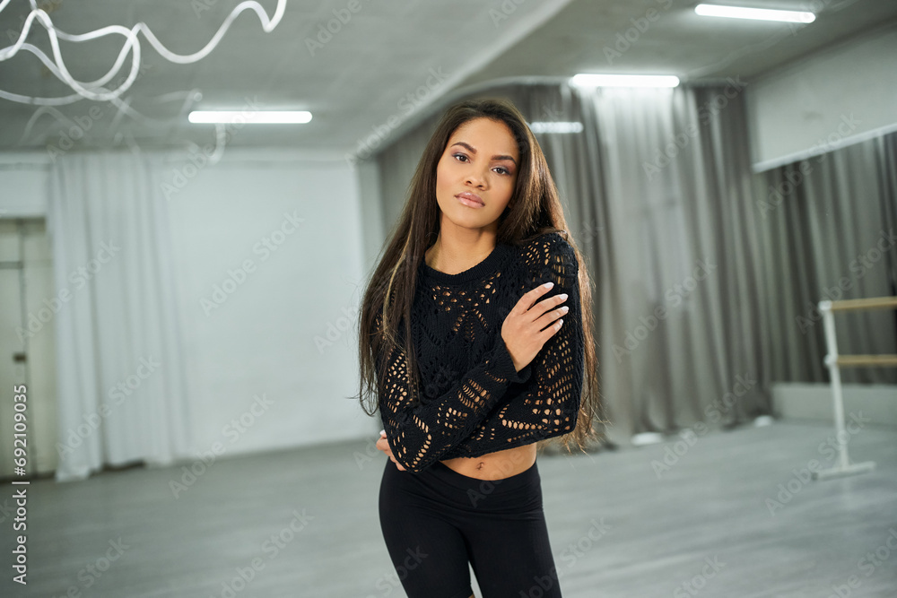 charming long-haired african american woman in black crop sweater dancing and looking at camera charming long-haired african american woman in black crop sweater dancing and looking at camera