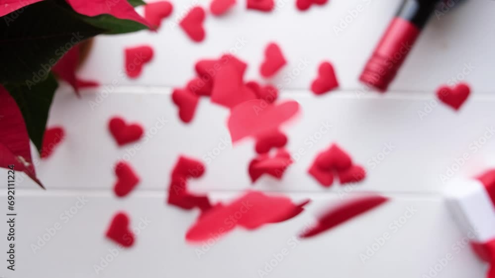 Valentines day. heart shaped confetti falling on white wooden table decorated for valentines day Valentines day. heart shaped confetti falling on white wooden table decorated for valentines day