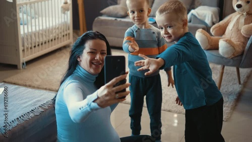 Pregnant mother and smal children doing a video call at home photo