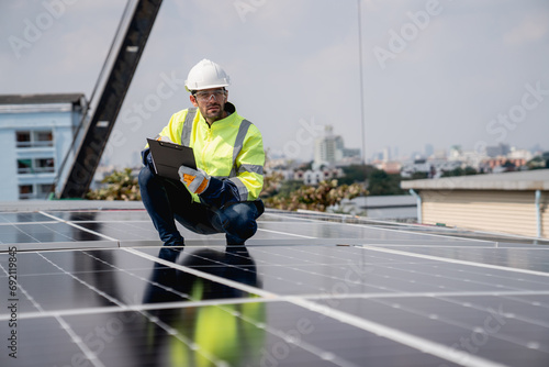 Service engineer installing solar cell on the roof of factory. Technicians working about solar panel system outdoors. Clean and Renewable energy concept.
