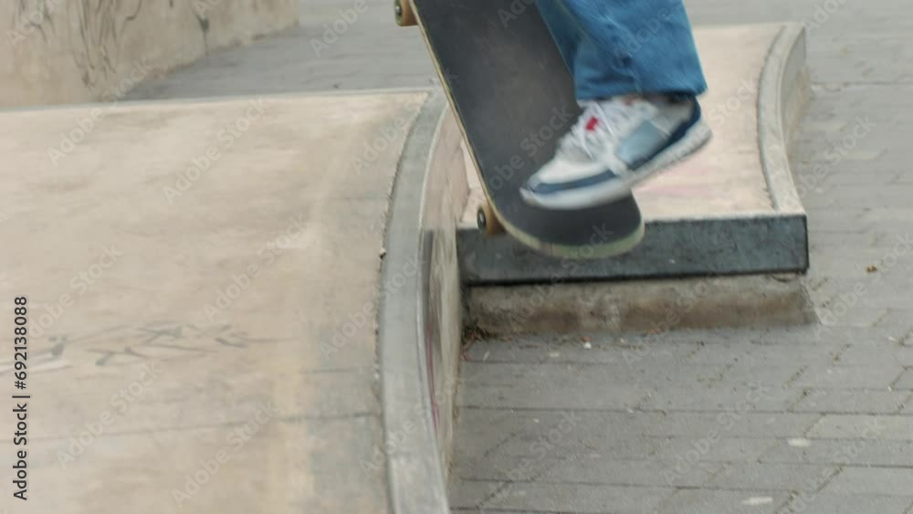 Young skater making 360 flip jump, performing kickflip trick, skateboarder training in skatepark, making tricks, slides and flips, professional extreme sport athlete training ride on skateboard. Young skater making 360 flip jump, performing kickflip trick, skateboarder training in skatepark, making tricks, slides and flips, professional extreme sport athlete training ride on skateboard.