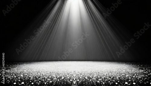 twinkling glitter falling on a flat surface lit by a bright spotlight elegant black and white stage background photo