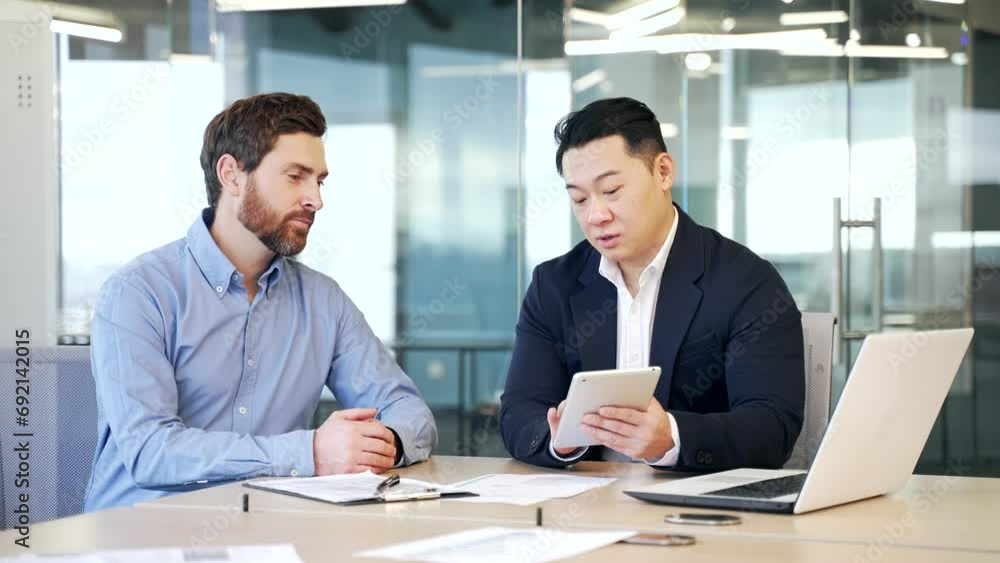 Business men discussing financial market data using laptop and digital tablet. Two diverse employees communicate Financial advisor broker manager consult investor client investment at office meeting Business men discussing financial market data using laptop and digital tablet. Two diverse employees communicate Financial advisor broker manager consult investor client investment at office meeting