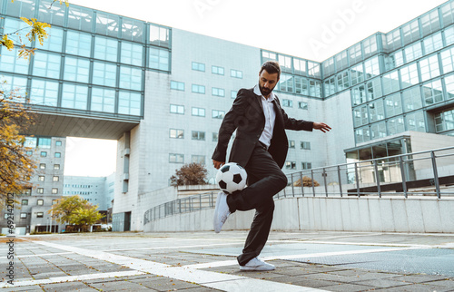 Businessman playing with a soccer ball and making freestyle tricks photo
