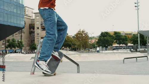 Young skater making 360 flip jump, performing kickflip trick, skateboarder training in skatepark, making tricks, slides and flips, professional extreme sport athlete training ride on skateboard.  photo