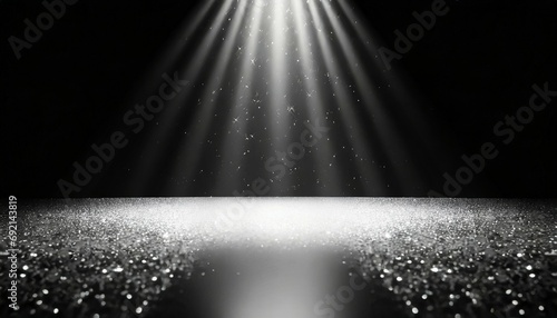 twinkling glitter falling on a flat surface lit by a bright spotlight elegant black and white stage background