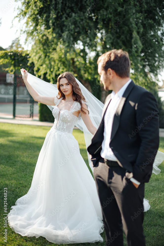Portrait of bride and groom embracing and posing on a background of garden. Loving couple posing together. Stock photo Portrait of bride and groom embracing and posing on a background of garden. Loving couple posing together. Stock photo