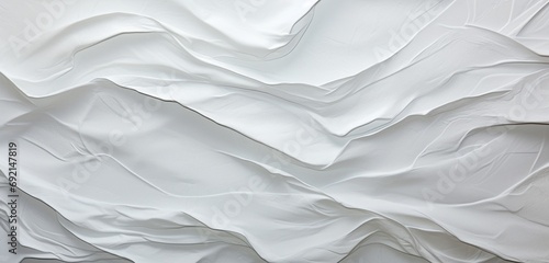 Explore the intriguing close-up of a background made of crumpled white paper, offering an abstract yet captivating space with ample copy space. The texture invites you to contemplate its unique form.