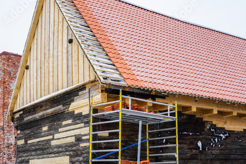 Restoration of a ancient wooden house, clay tile roof and damaged part of walls replacement