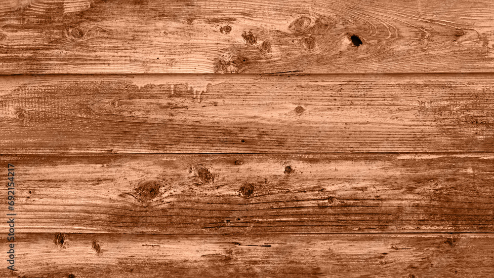 Fototapeta premium The background of old wooden boards painted in new trendy color of 2024 year Peach Fuzz. Texture top view. Blog backdrop for text signs design. Abstract wallpaper, wooden surface.