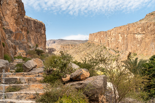 Mountain path with date palm trees oasis at Misfah al Abriyyin or Misfat Al Abriyeen village located in the north of the Sultanate of Oman. photo