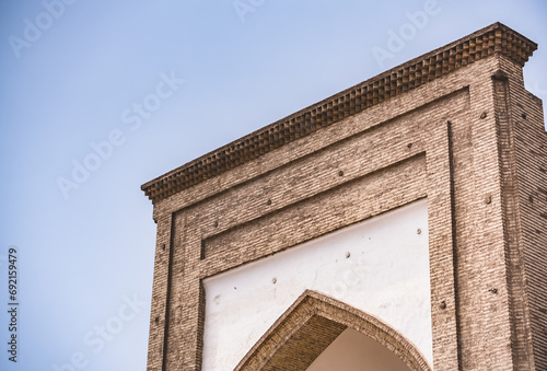 Ancient facade of a mosque made of brick with cladding in the ancient city of Khiva in Khorezm photo