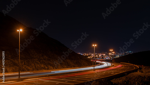 Mountain Glow: Khor Fakkan Highway Light Trails in the Dark photo