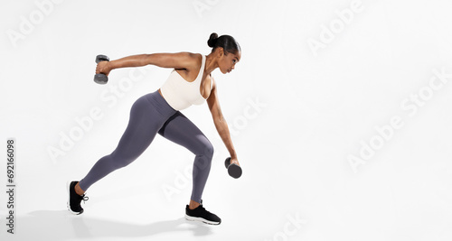 Fototapeta Naklejka Na Ścianę i Meble -  African American Fitness Woman Exercising With Dumbbells On White Background