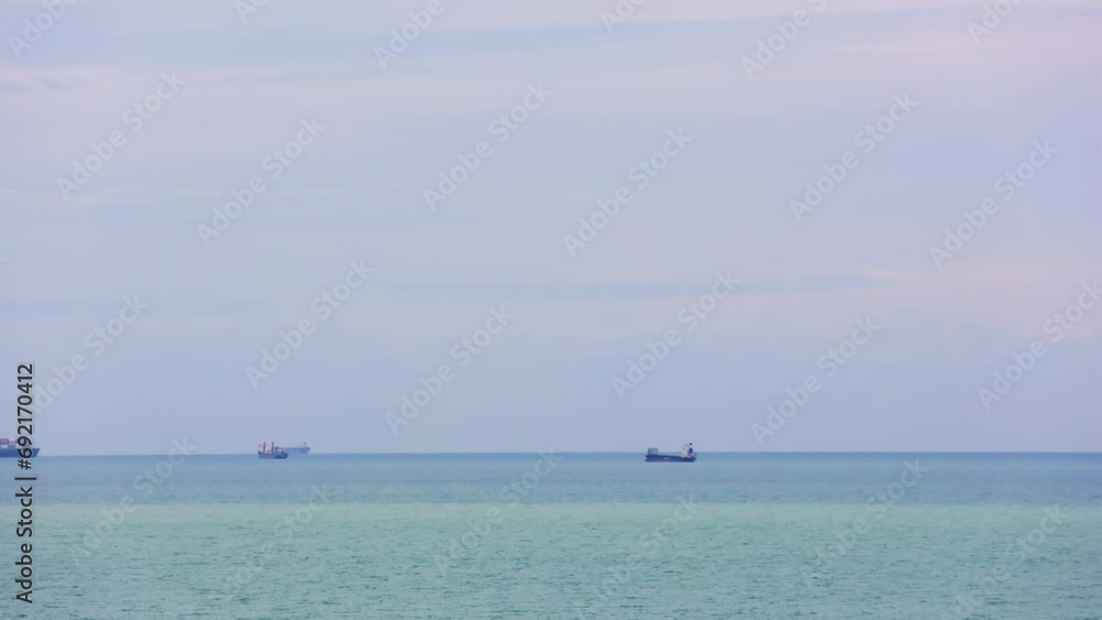 Anchored ships at Mersin, Turkey, with sunset over Mediterranean. Cargo container ship anchored near coast, awaiting port. Industrial anchored ship at Turkish seafront at dusk Anchored ships at Mersin, Turkey, with sunset over Mediterranean. Cargo container ship anchored near coast, awaiting port. Industrial anchored ship at Turkish seafront at dusk