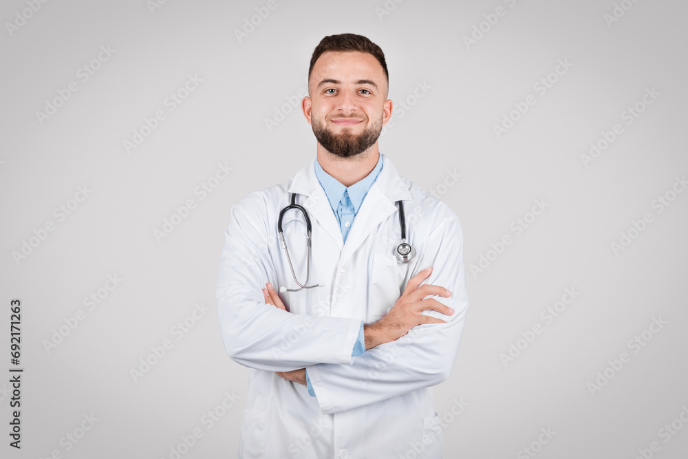 Smiling male doctor with arms crossed in lab coat Smiling male doctor with arms crossed in lab coat